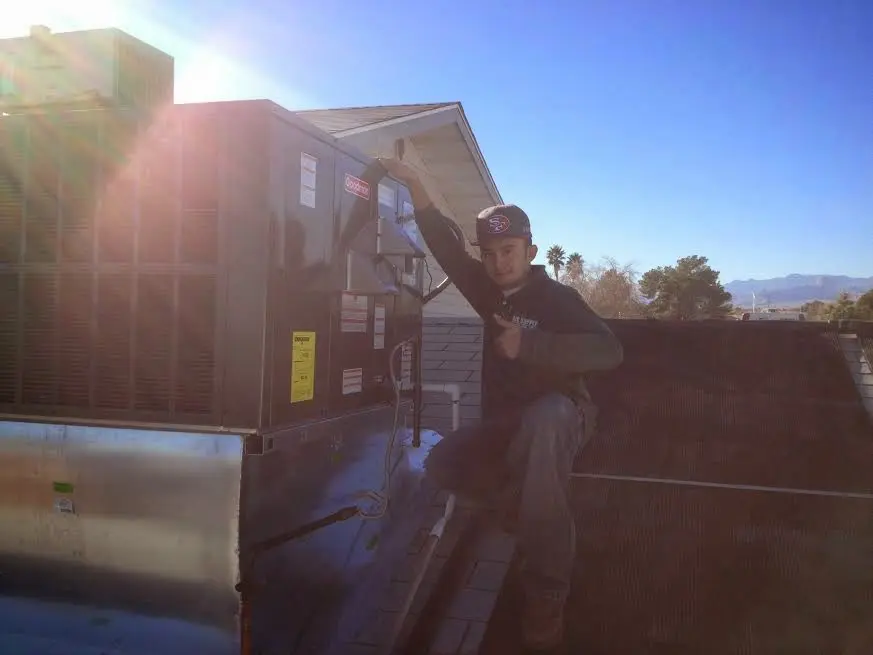 HVAC technician performing Boiler Repair on a rooftop unit in Henrietta
